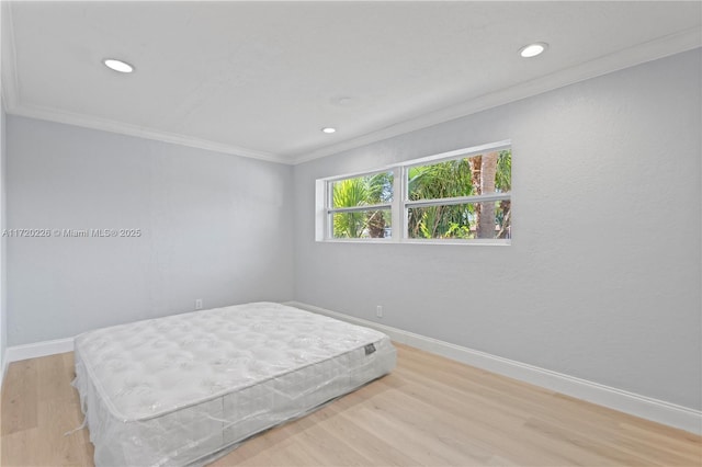 bedroom featuring crown molding and light hardwood / wood-style flooring