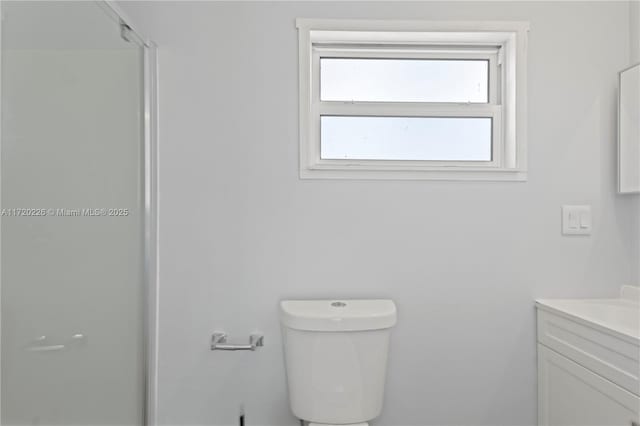 bathroom featuring an enclosed shower, vanity, and toilet