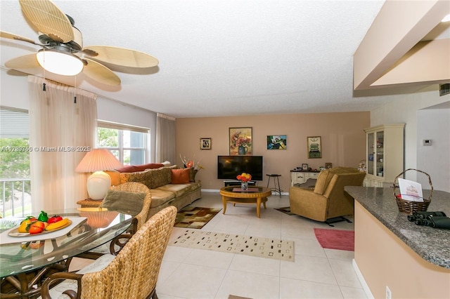 living room with light tile patterned floors, a textured ceiling, and ceiling fan