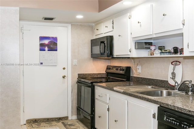 kitchen featuring sink, tasteful backsplash, white cabinets, light tile patterned flooring, and black appliances