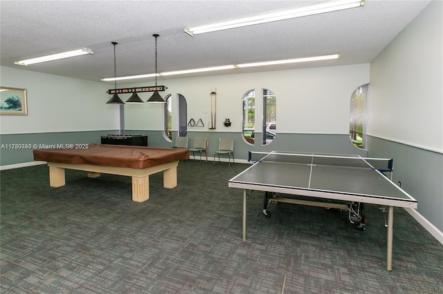 game room with a textured ceiling, dark carpet, and billiards