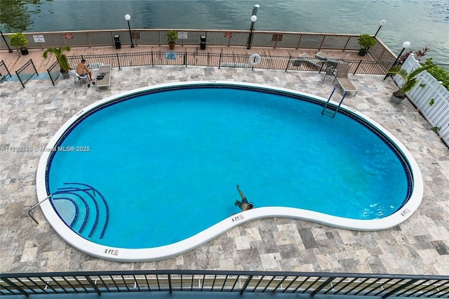 view of swimming pool featuring a water view