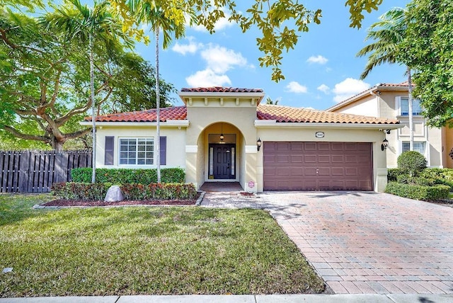 mediterranean / spanish home with a front yard and a garage