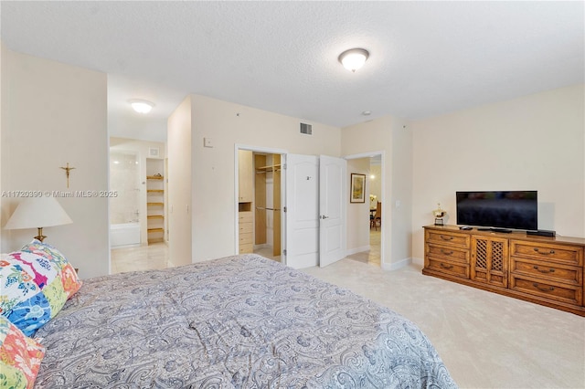 carpeted bedroom with a spacious closet, a closet, and a textured ceiling