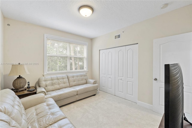 carpeted living room featuring a textured ceiling