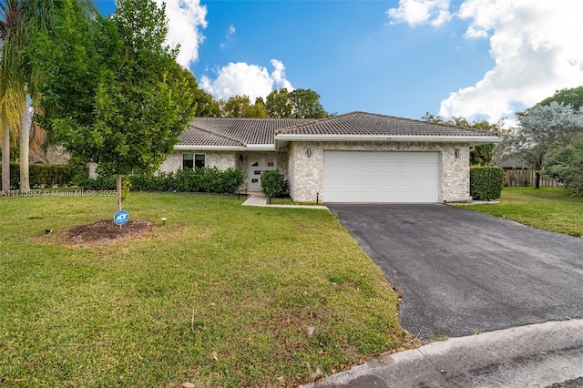 ranch-style house featuring a garage and a front lawn