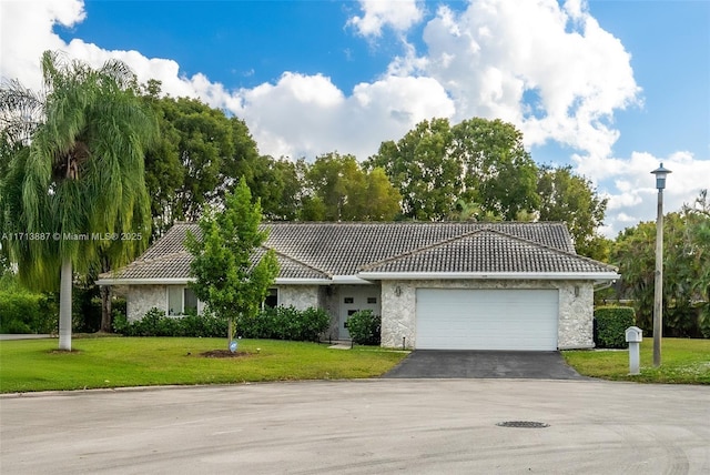 ranch-style home featuring a garage and a front yard