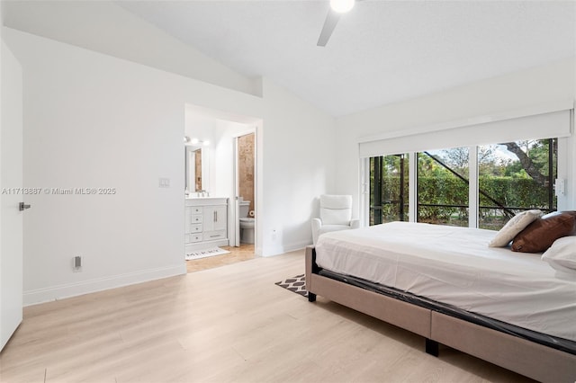 bedroom featuring ceiling fan, light hardwood / wood-style floors, ensuite bathroom, and vaulted ceiling