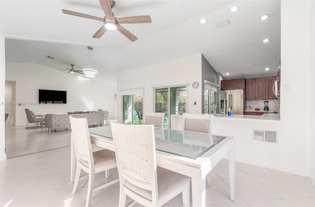 dining area with ceiling fan, light tile patterned flooring, and lofted ceiling