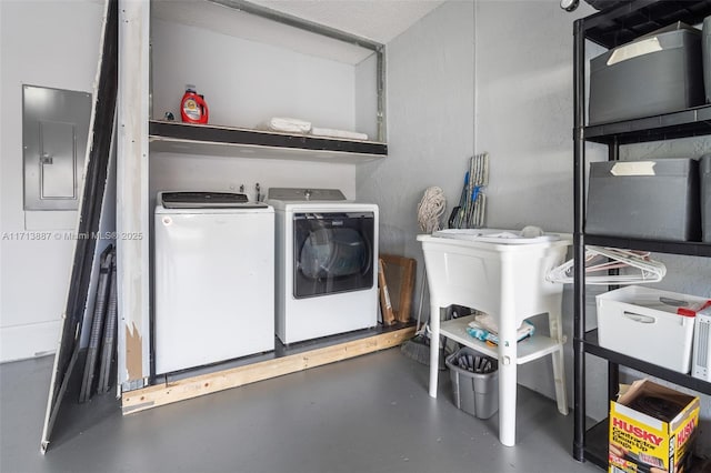 clothes washing area with washer and clothes dryer and electric panel