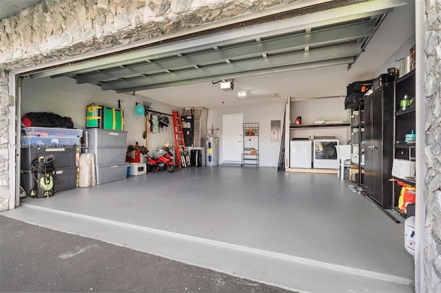 garage featuring washing machine and dryer, a garage door opener, and water heater