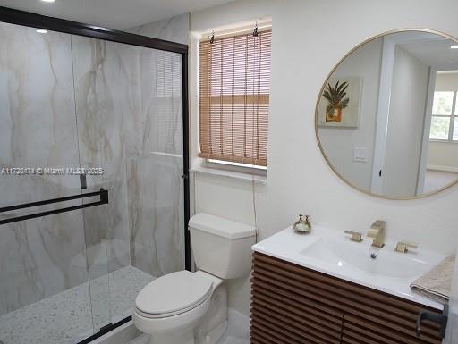 bathroom with toilet, walk in shower, and vanity