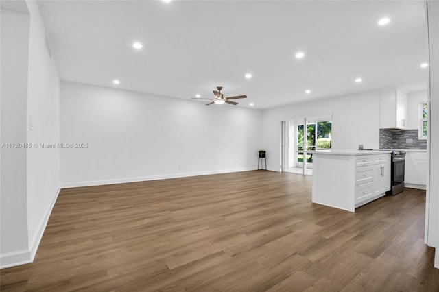 kitchen with ceiling fan, tasteful backsplash, stainless steel range with electric cooktop, kitchen peninsula, and white cabinets