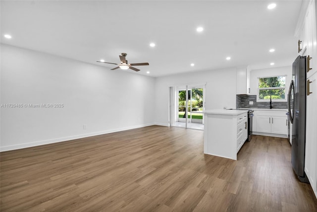 kitchen with white cabinetry, ceiling fan, stainless steel appliances, and hardwood / wood-style flooring