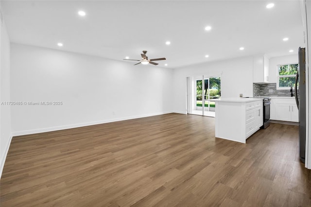 kitchen with ceiling fan, stainless steel appliances, dark hardwood / wood-style floors, backsplash, and white cabinets