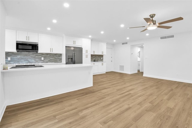 kitchen with white cabinets, stainless steel fridge, light hardwood / wood-style floors, and ceiling fan