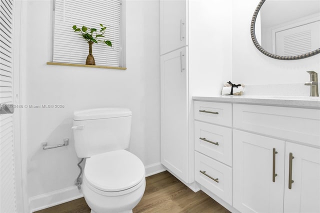 bathroom with vanity, wood-type flooring, and toilet