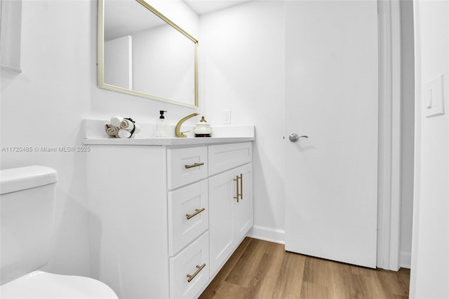 bathroom featuring hardwood / wood-style flooring, vanity, and toilet