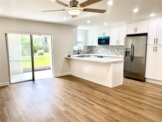 kitchen featuring ceiling fan, stainless steel fridge with ice dispenser, backsplash, light hardwood / wood-style floors, and white cabinets