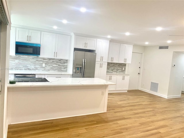 kitchen featuring white cabinets, decorative backsplash, stainless steel refrigerator with ice dispenser, and light hardwood / wood-style flooring