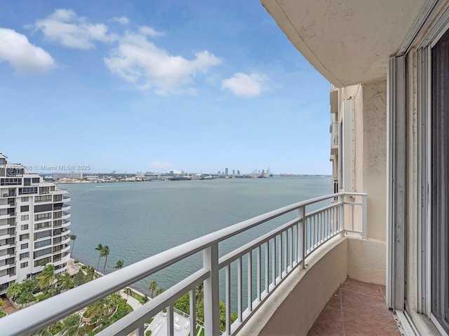 balcony featuring a water view and a city view