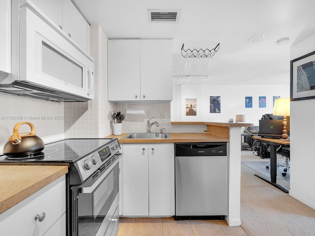 kitchen featuring light countertops, visible vents, decorative backsplash, appliances with stainless steel finishes, and a sink