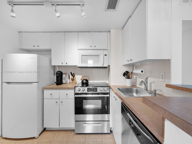 kitchen featuring stainless steel appliances, visible vents, decorative backsplash, white cabinetry, and a sink