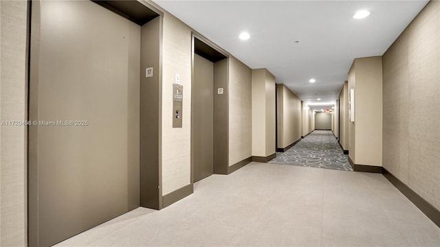 hall with recessed lighting and elevator