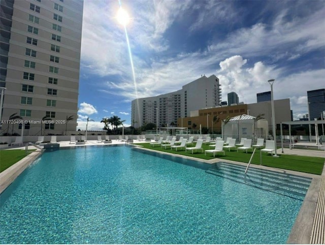 pool with a patio area and a city view