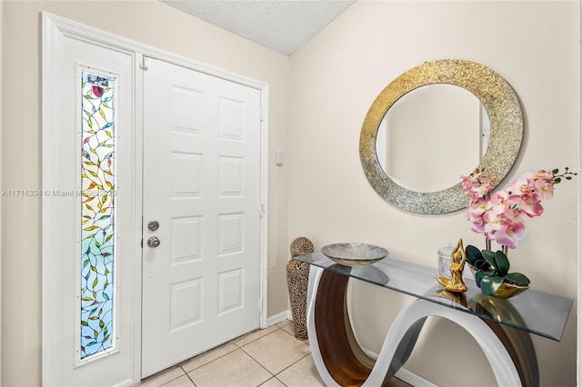 tiled entryway with a textured ceiling