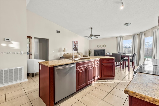 kitchen with ceiling fan, sink, light tile patterned floors, stainless steel dishwasher, and a kitchen island