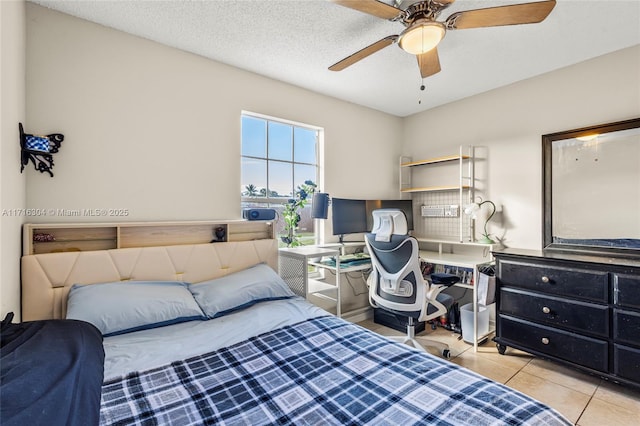 tiled bedroom featuring ceiling fan and a textured ceiling