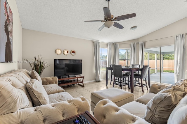 living room featuring light tile patterned floors, a textured ceiling, ceiling fan, and lofted ceiling