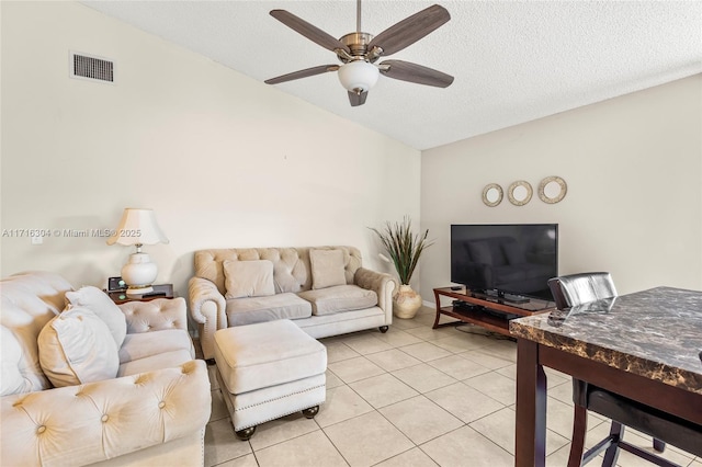 tiled living room featuring a textured ceiling, ceiling fan, and lofted ceiling