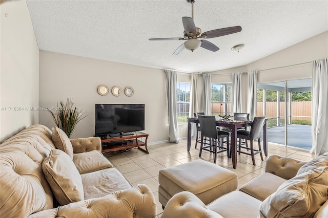 living room with ceiling fan, light tile patterned floors, a textured ceiling, and lofted ceiling