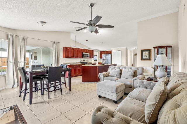 tiled living room with ceiling fan, a textured ceiling, and vaulted ceiling