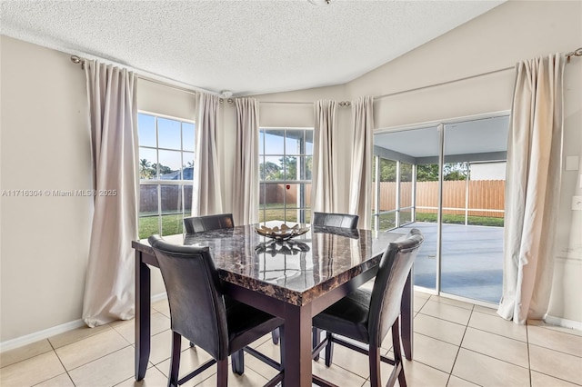 dining space featuring light tile patterned floors and a textured ceiling