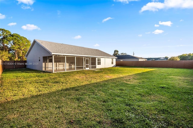 rear view of house featuring a sunroom and a yard