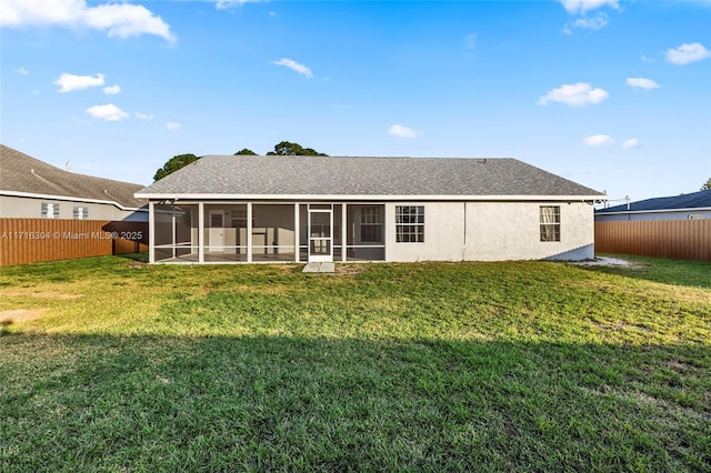 back of property featuring a lawn and a sunroom