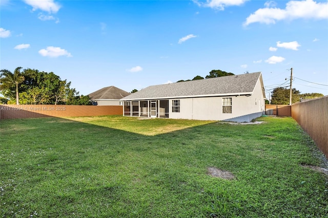 back of property featuring a lawn and a sunroom