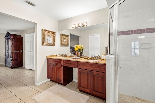 bathroom with tile patterned flooring, vanity, and walk in shower