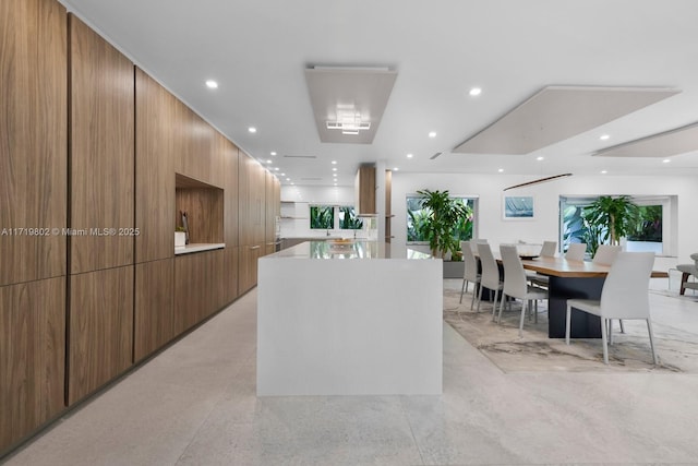 kitchen with modern cabinets, a kitchen island, brown cabinets, and recessed lighting