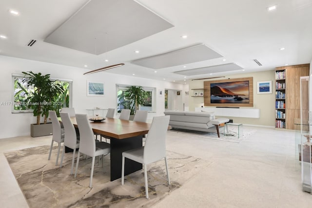 dining area featuring a tray ceiling, marble finish floor, visible vents, and recessed lighting