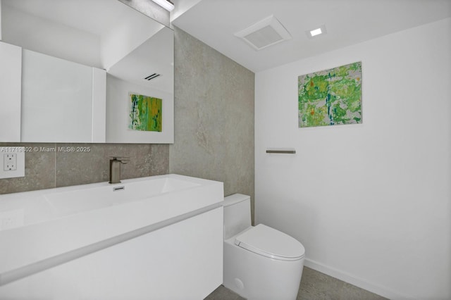 bathroom featuring visible vents, vanity, toilet, and baseboards