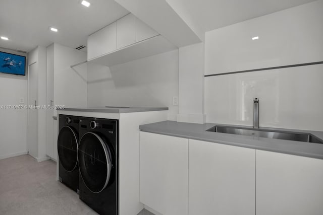 clothes washing area featuring laundry area, separate washer and dryer, and a sink