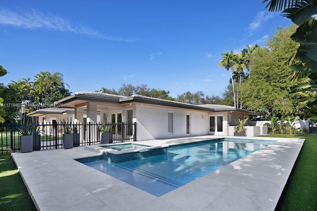 view of swimming pool featuring a patio area, a pool with connected hot tub, and fence