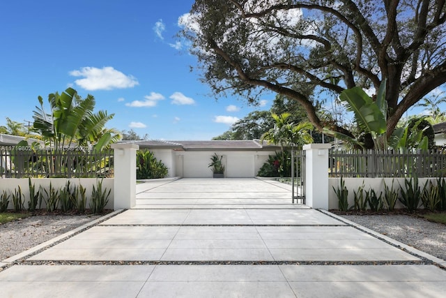 4144 Pinta Ct, Coral Gables, FL 33146 - view of front of property featuring a fenced front yard, a gate, driveway, an attached garage, and stucco siding