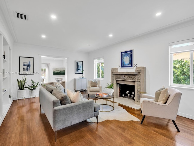 living room with crown molding, recessed lighting, wood finished floors, and visible vents