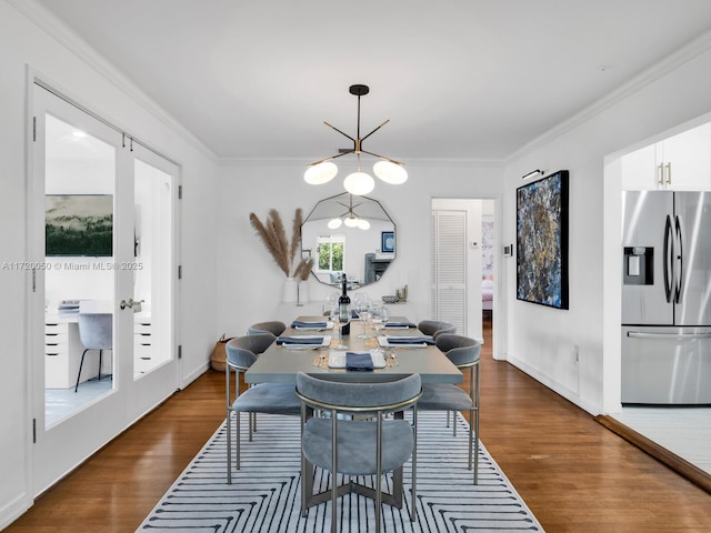 dining space with baseboards, an inviting chandelier, dark wood-style flooring, and crown molding