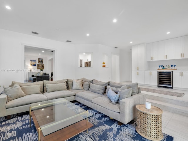 living area with beverage cooler, visible vents, recessed lighting, arched walkways, and a dry bar